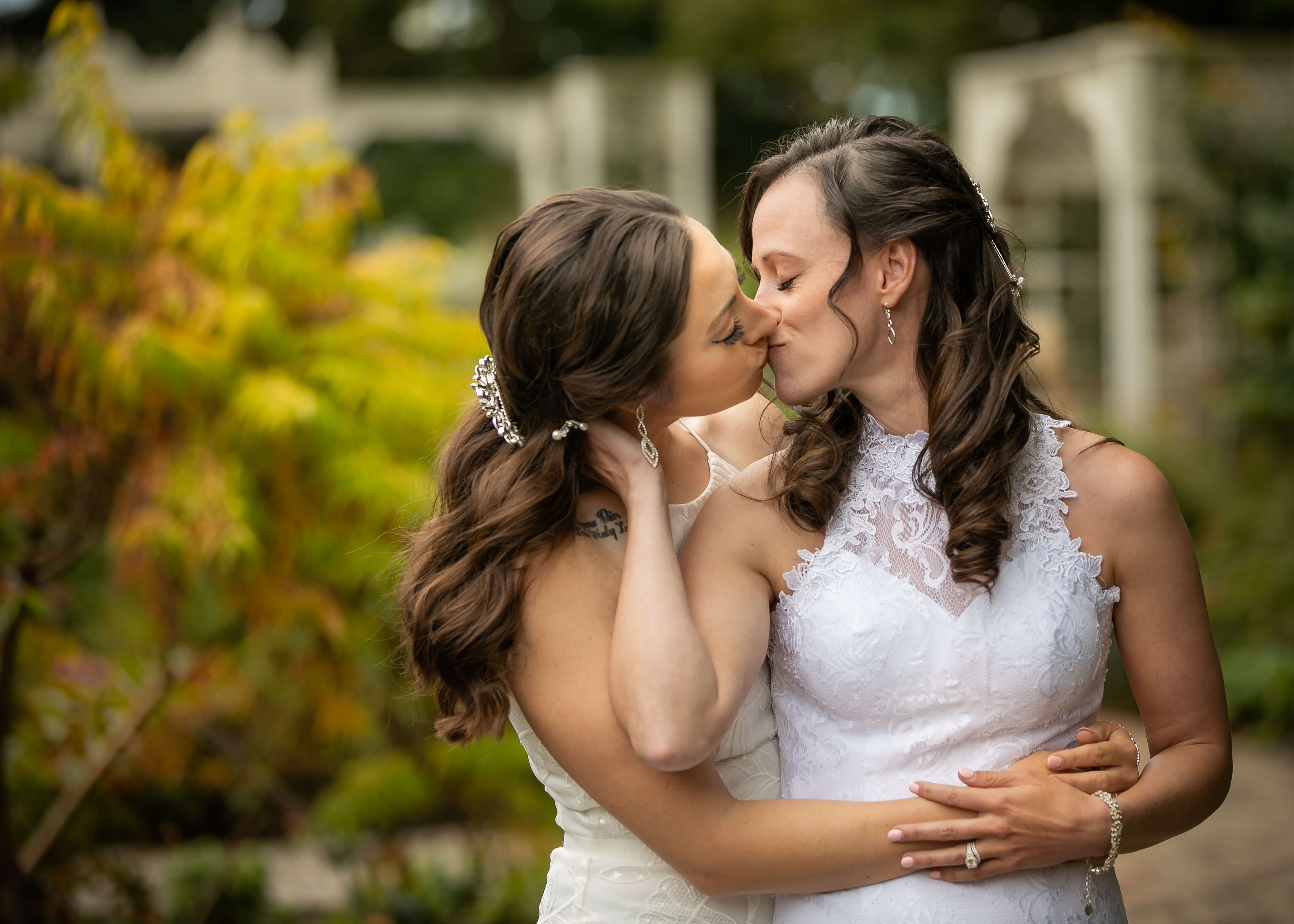 two brides kissing in wedding gowns