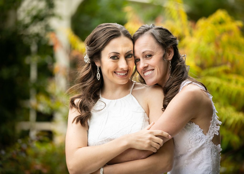 two brides smiling and hugging 
