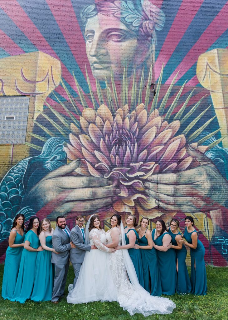 wedding party posed against colorful wall mural in Cleveland